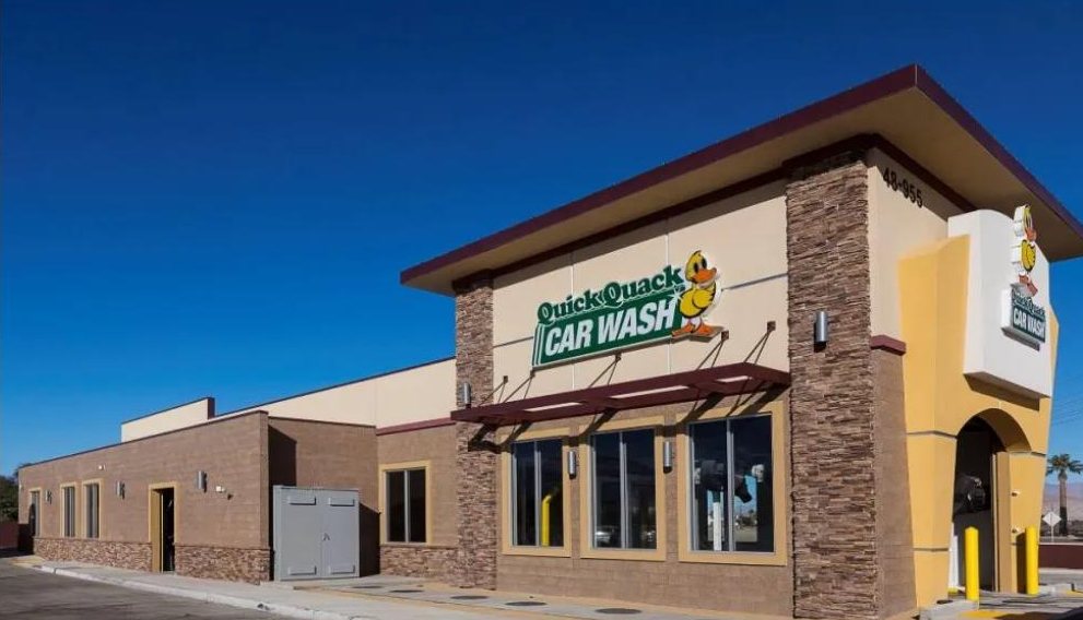 Completed Quick Quack Car Wash building with stone veneer and brand signage