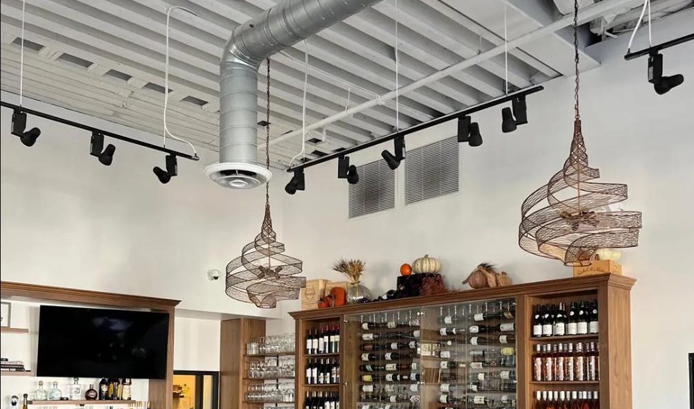 Brightwaters Wine Bar interior with spiral pendant lights and a full wine display wall